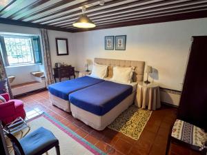 a bedroom with a blue bed in a room at Casa da Quinta De S. Martinho in Vila Real +134 photos