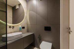 Un baño con lavabo, inodoro y espejo. en LupoApartments Premium Łazowskiego, Parking, Dostęp na Kod, 3 Sypialnie, en Łódź 34 fotos más