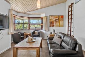 a living room with a leather couch and a table at 0335-Romo-Vestergardsvaenget-2 in Vesterhede