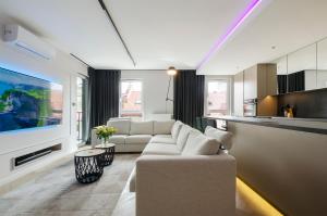 Una sala de estar con un sofá y un televisor. en LupoApartments Premium Łazowskiego, Parking, Dostęp na Kod, 3 Sypialnie, en Łódź