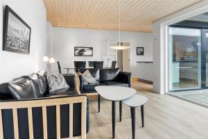 Una sala de estar con un sofá de cuero negro y una mesa. en 0341-Romo-Vestergade-351, en Sønderby