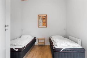 Habitación con 2 camas, paredes blancas y suelo de madera. en 0341-Romo-Vestergade-351, en Sønderby