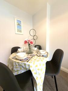 a dining room table with a vase of flowers on it at Jambow Blue in Filey +38 photos