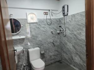 a bathroom with a shower and a toilet and a sink at RS Mahal in Jaffna