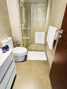 a bathroom with a toilet and a shower with towels at YAKA Residences - Trizen Luxury Apartments in Colombo +80 photos
