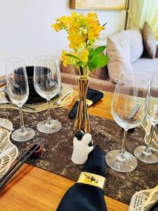 a table with wine glasses and a vase with flowers at YAKA Residences - Trizen Luxury Apartments in Colombo