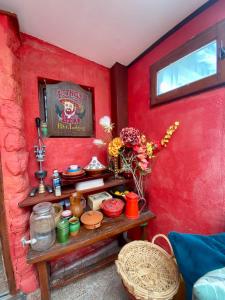 a red wall with a wooden table in a room at Le Mas des Vignes parisian hacienda in Rueil-Malmaison