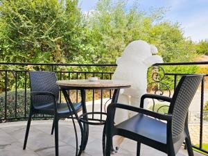 a table and chairs on a balcony with a statue at Jata Hotel in Tirana