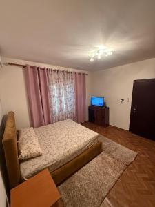 Un pequeño dormitorio con una cama y un televisor. en Cosy House, en Tirana