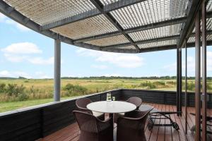 een terras met een tafel en stoelen op een dek bij 0343-Romo-Vestergade-329 in Sønderby