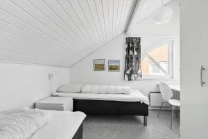 une chambre blanche avec deux lits et une fenêtre dans l'établissement 0354-Romo-Feriencenter-RIM-159-Ap-201, à Sønderby 29 autres photos