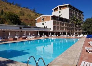 a large swimming pool in front of a hotel at Charmoso Flat 309 Cavalinho Branco in Águas de Lindoia