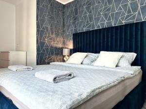 a bedroom with a large bed with towels on it at Walońska 19 Apart - SPA & Parking in Wrocław