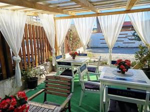 a patio with white tables and chairs and white curtains at Vila ANA in Cluj-Napoca