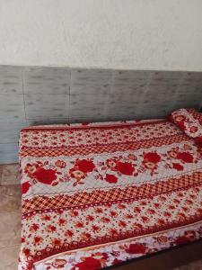 un letto con una coperta rossa e bianca sopra di Sawami Kingsplace Resort ad Abuja