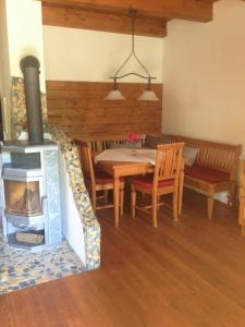 ein Wohnzimmer mit einem Tisch und einem Holzofen in der Unterkunft Romantik Chalet in Breitenbrunn