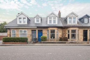 a house with a blue door on a street at Cairnhill House - cosy 3 bedroom in Airdrie