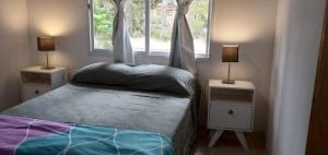 Un dormitorio pequeño con una cama y dos mesitas de noche. en a 1 del mar 2, en Mar Azul