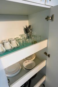 a cupboard with plates and dishes on a shelf at Hermoso y cómodo loft con vista a los nevados in Riobamba +52 photos