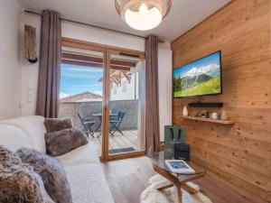 ein Wohnzimmer mit einer Couch, einem Fernseher und einem Tisch in der Unterkunft Appartement charmant 4 pers, piste proche, parking, Les Saisies - FR-1-809-13 in Les Saisies