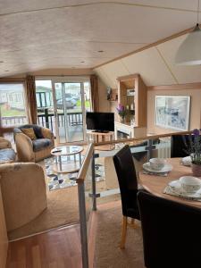 a living room with a table and some chairs at Beach Retreat in Ynys-lâs Station