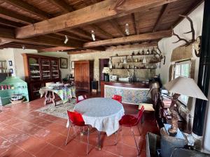 a living room with a table and red chairs at Casa da Quinta De S. Martinho in Vila Real