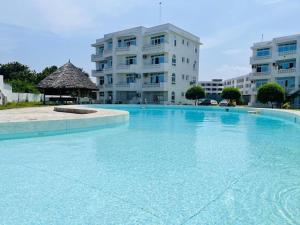 a large swimming pool in front of a building at Kijani unique home Malindi in Malindi
