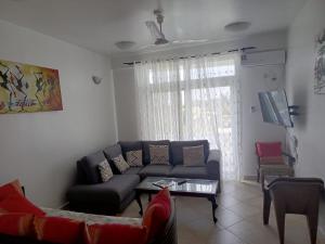 a living room with a couch and a tv at Kijani unique home Malindi in Malindi