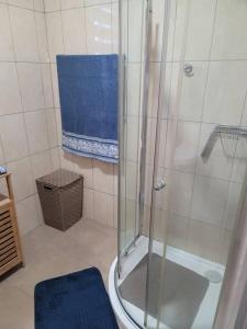 a bathroom with a shower and a blue towel at Legacy Square by QUAO REALTY in East Legon