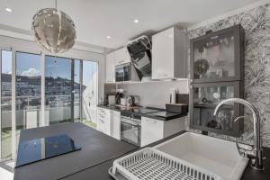 a kitchen with white appliances and a large window at Entre el cielo y el mar Puerto Rico in Mogán