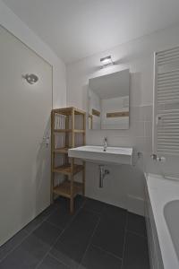 a bathroom with a sink and a mirror and a tub at Villasimius 8 - Celerina in Celerina
