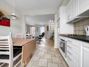 Sønderbyにある0417-Romo-Vestergade-199-Ap-182の白いキャビネットとテーブルと椅子のあるキッチン