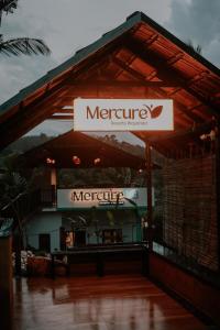 a restaurant with a sign on top of a building at Mercure Resort Wayanad in Mananthavady
