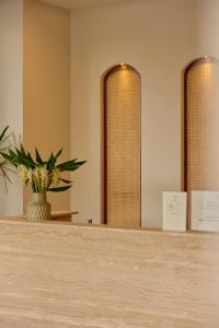 a counter with two mirrors and a potted plant at Ten Boutique Hotel Oldtown Chiangmai in Chiang Mai