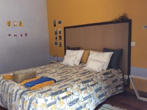 Un dormitorio con una cama grande con almohadas. en Patacão&Violeta, en Faro