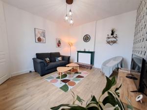 a living room with a couch and a table at Le 84bis, maison, proche gare, parking, Netflix in Laval