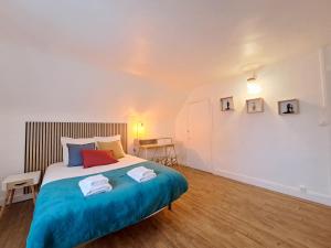 a bedroom with a large bed with blue sheets at Le 84bis, maison, proche gare, parking, Netflix in Laval