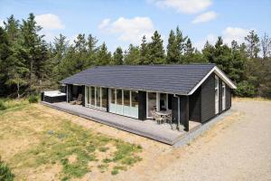 a black house with a deck in a field at 0122-Romo-Smafolksvej-44 in Høm