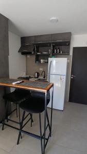 a kitchen with a table and a refrigerator at Confort y Cercania Ezeiza in Ezeiza +9 photos