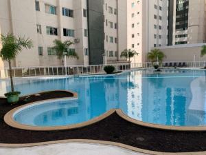a large swimming pool in front of a building at Apto Cittá in Brasília