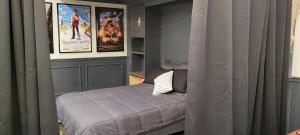 a bedroom with a bed and posters on the wall at Modern Loft with Immersive Theatre Experience in Milton