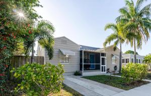 a house with palm trees in front of it at Casa Little Beach House in Lake Worth