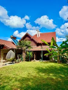 a house with a red roof and a yard at Guest House Yanakievi in Sinemorets