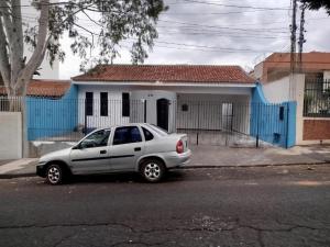 a silver car parked in front of a blue house at Refúgio Hostel Unidade 3 in Bauru