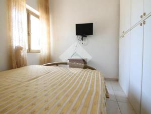 ein Schlafzimmer mit einem Bett und einem Fernseher an der Wand in der Unterkunft Villa ciro in Ostuni