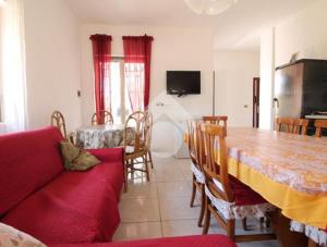 ein Wohnzimmer mit einem roten Sofa und einem Tisch in der Unterkunft Villa ciro in Ostuni