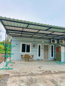 Un patio con toldo y sillas y una mesa. en Adriana RH Homestay 3Bedroom 2Bathroom, en Kampong Bukit Rambai