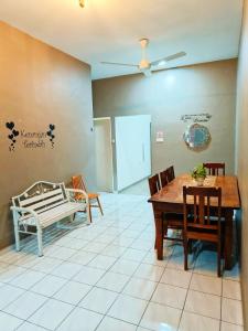 Un comedor con mesa y sillas en Adriana RH Homestay 3Bedroom 2Bathroom, en Kampong Bukit Rambai