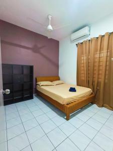 un dormitorio con una cama en una habitación en Adriana RH Homestay 3Bedroom 2Bathroom, en Kampong Bukit Rambai