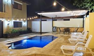 a swimming pool in a patio with chairs and a table at Casa Luz de Luna - Comfortable 3 Br, 3,5 Bath house in Potrero